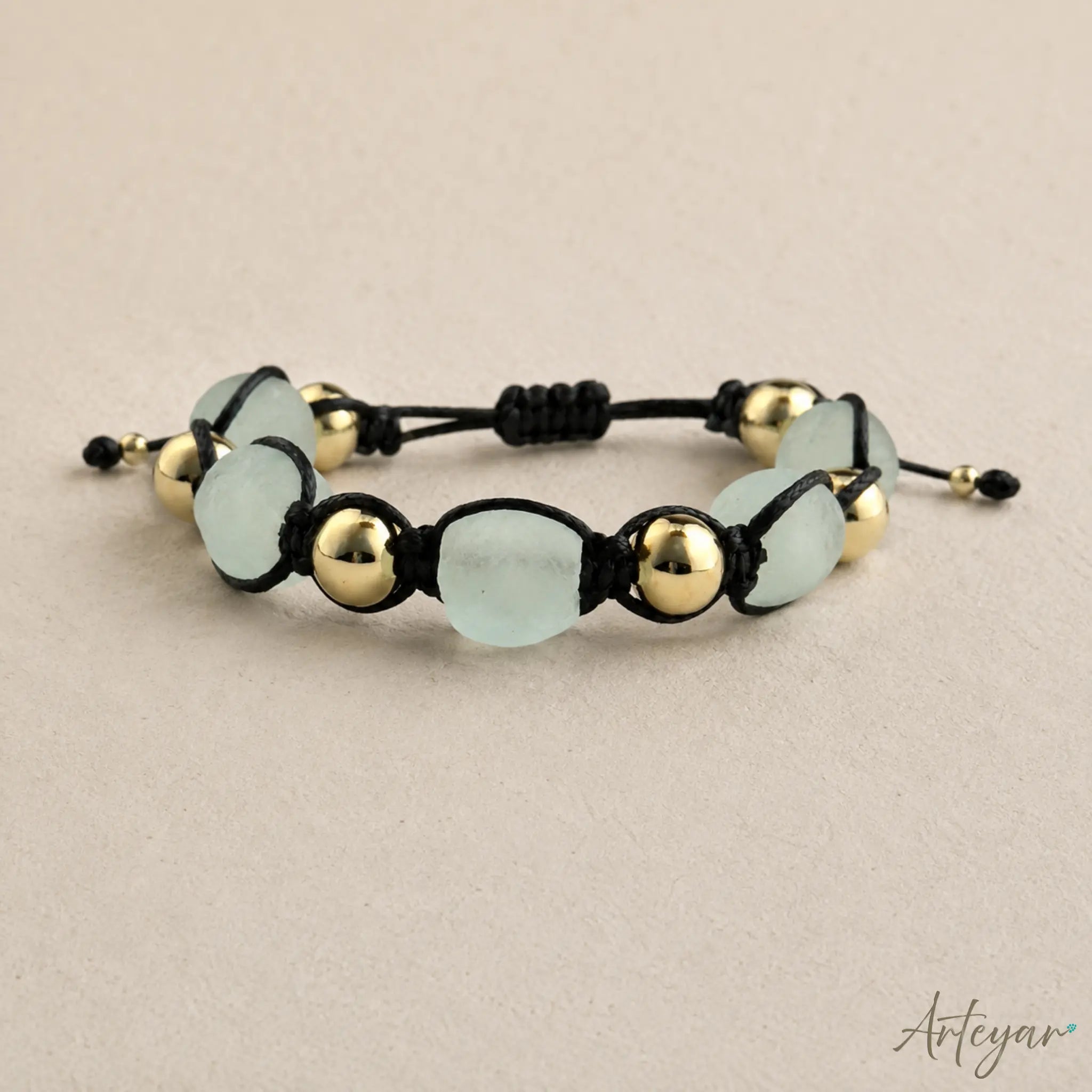 Elegant Unisex Bracelet with Mint Green Ganha Beads and Golden Accents on a Black Cord, Menta Design by Arteyar, Modern and Sophisticated Adjustable Jewelry for Everyday Wear.
