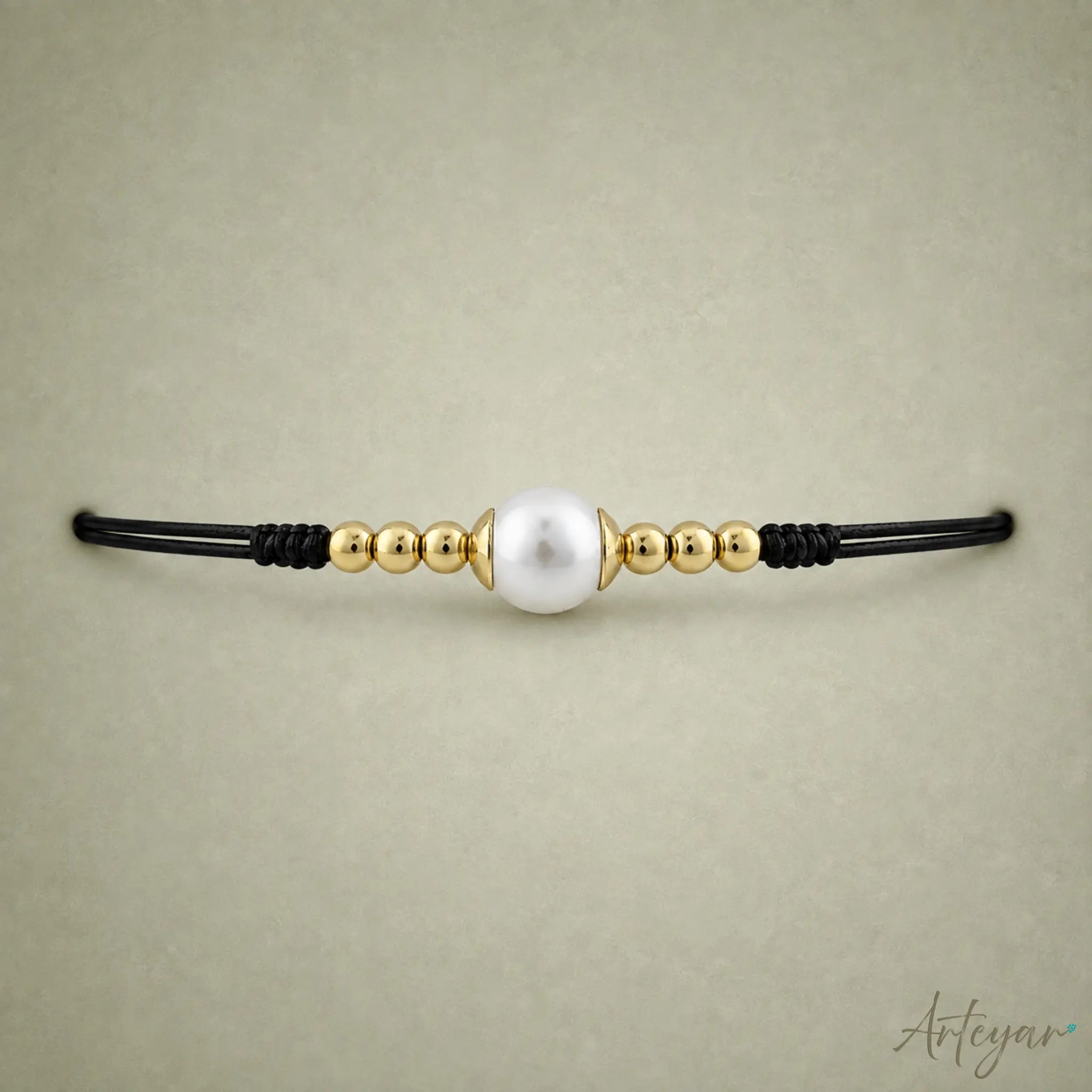 Elegant Black Cord Bracelet with a Luminous Central Pearl and Golden Beads, Lia Design by Arteyar, Minimalist and Classic Jewelry, Perfect for Solo Wear or Stacking.