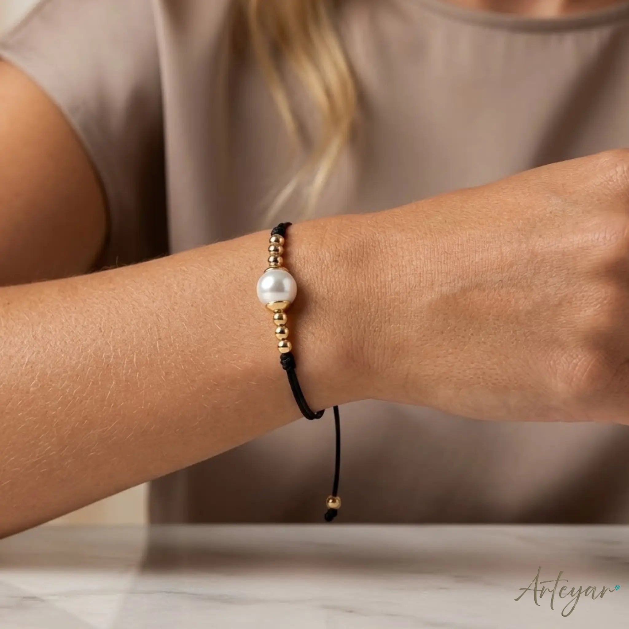 Elegant Black Cord Bracelet with a Luminous Central Pearl and Golden Beads, Lia Design by Arteyar, Minimalist and Classic Jewelry, Perfect for Solo Wear or Stacking.